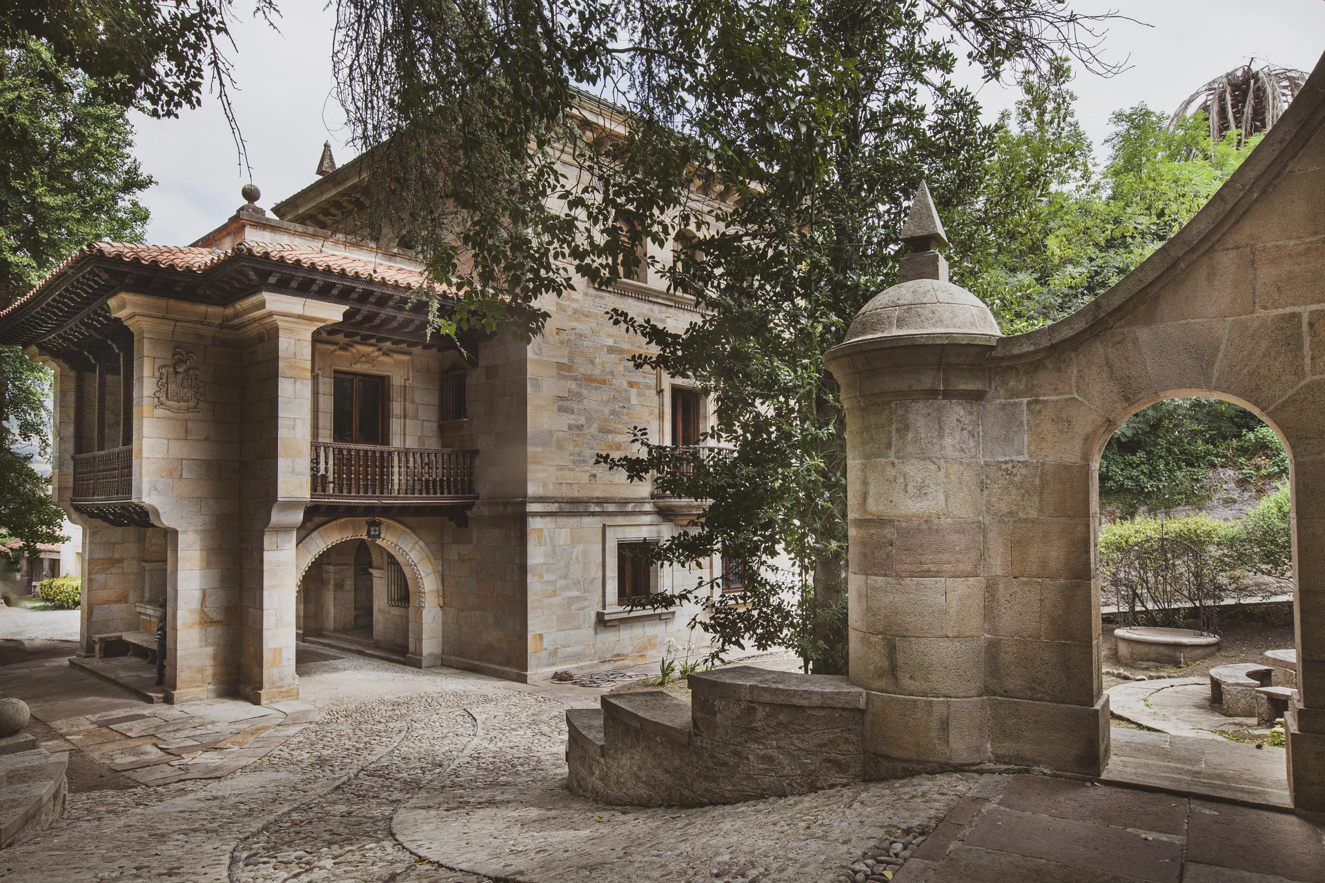 Entrada de piedra al Palacio y arco de acceso al jardín.